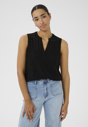 Haut sans manches noir avec un motif texturé et un col fendu, associé à un jean taille haute bleu clair.