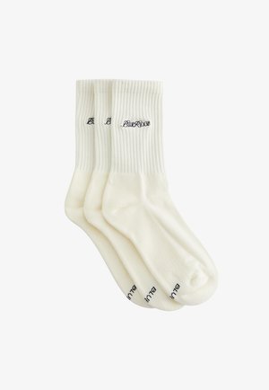 Tre paia di calzini bianchi modello crew con polsini a costine e scritta nera "BLUERIDGE" ricamata vicino alla parte superiore e alle dita.