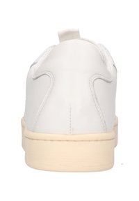 Sneaker bianche in pelle con forma arrotondata, superficie liscia e suola in gomma beige chiaro. Presenta una piccola linguetta sul retro per facilitare indossarle.