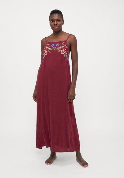 Maxi dress bordeaux con ricami floreali in rosa e blu, dotato di spalline sottili e una silhouette fluida. Realizzato in tessuto leggero.