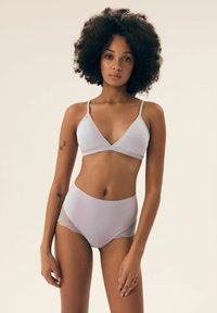 Jasnoszary zestaw bielizny z trójkątnym biustonoszem i wysokimi majtkami. Biustonosz ma cienkie ramiączka; majtki mają teksturowany koronkowy akcent.