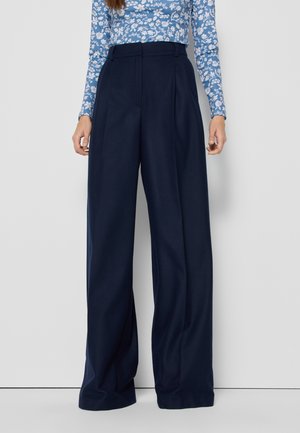 Navywijde broek met voorplooien, op maat gemaakte taille en rechte snit. De stof lijkt soepel en lichtgewicht.