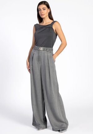 Grijs draped tanktop met een gedraaide schouderdetail, gecombineerd met grijze wijde broek met plooien en een gestructureerde riem.