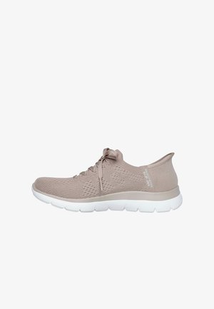 Zapatilla deportiva beige claro con parte superior de punto transpirable, diseño con cordones, suela blanca acolchada y marca sutil en el talón.