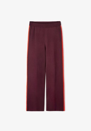 Spodnie o szerokich nogawkach w kolorze burgundowym, z kontrastującymi pomarańczowymi paskami po bokach, prążkowanym pasem oraz dwoma bocznymi kieszeniami. Gładka tekstura materiału.