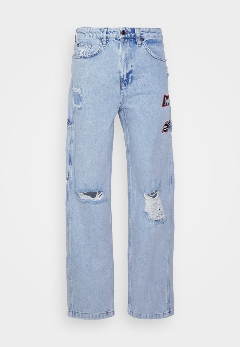 Jeans in denim blu chiaro con dettagli strappati, dotati di toppe di varie forme e colori sulla parte anteriore, vestibilità rilassata e gamba dritta.