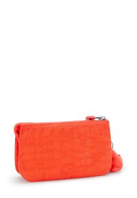 Small rectangular bright orange fabric pouch with zipper and round fuzzy pull tab on white background.