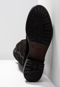 Stivaletto in camoscio nero con suola in gomma testurizzata, cerniere laterali e punta rotonda. Taglia contrassegnata come 37.