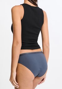 Czarny prążkowany top na ramiączkach w zestawie z ciemnoszarymi majtkami z błyszczącym paskiem, gładkim materiałem i wysokim krojem.
