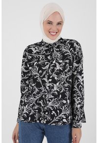 Black and white floral blouse with long sleeves, button closure, and a collared neckline. Fabrics feature a smooth, lightweight texture.