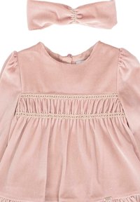 Robe pour bébé en velours rose doux avec des détails smockés sur la poitrine et un bandeau assorti à volants.
