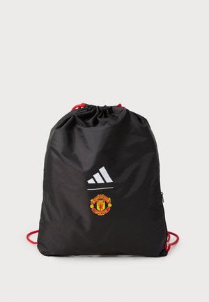 Musta narukassi nylonmateriaalia, jossa on punaiset narut, Adidas-logo ja Manchester Unitedin emblem etupuolella. Sujuva pinta, suorakulmainen muoto.