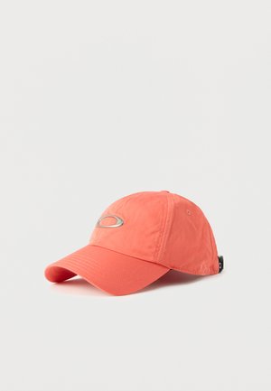 Gorra de béisbol color coral con paneles cosidos, visera curva y logo ovalado de metal en la parte frontal, presentada sobre un fondo blanco.