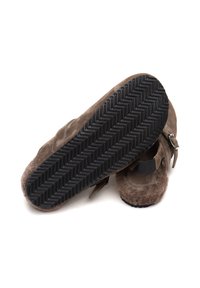 Scarpe slip-on in suede marrone con una suola in gomma scura texturizzata caratterizzata da un motivo a spina di pesce e un dettaglio con fibbia laterale.