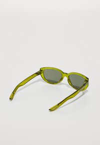 Ochelari de soare verzi cu rame rotunjite, fabricați din plastic transparent. Au lentile gri și brațe verzi texturate cu un design elegant.