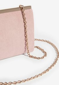 Roza ante kožna torbica s metalnim zlatnim zatvaračem na vrhu i lancem za nošenje, s glatkom, teksturiranom površinom i izduženim oblikom.