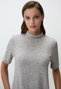Lichtgrijze, korte mouwen turtleneck top gemaakt van zacht, gestructureerd stof met een relaxte pasvorm en naadloze schouders.