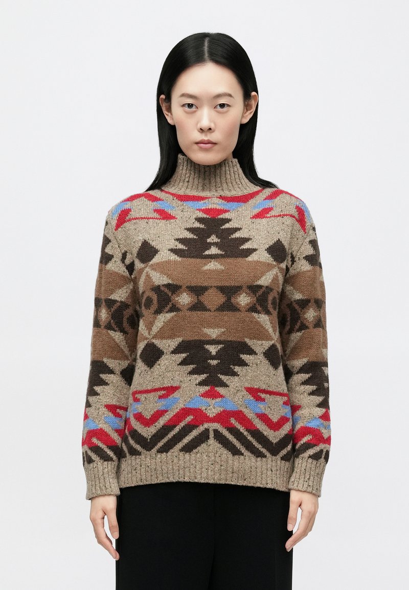 Tan strikket sweater med høj halsudskæring, med geometriske mønstre i brun, rød og blå. Ribstrikkede manchetter og kant, afslappet pasform.