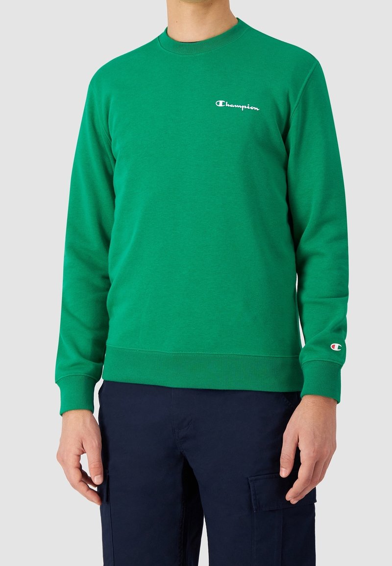 Zelená mikina vyrobená z bavlněné směsi s žebrovanými manžetami a spodním lemem. Obsahuje malé bílé logo na hrudi a detaily loga na rukávu.