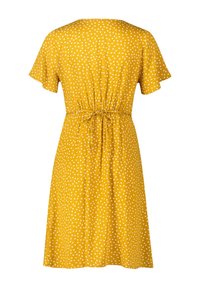 Robe jaune longueur genou à pois blancs, manches courtes et ceinture nouée à la taille, vue de dos.
