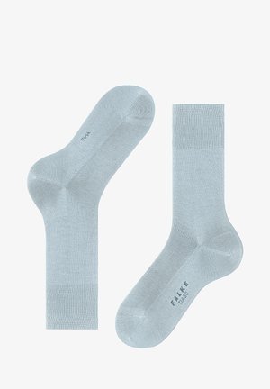 Jasnoniebieskie skarpetki wykonane z miękkiego materiału, charakteryzujące się gładką powierzchnią, ściągaczami i zaokrąglonym czubkiem.