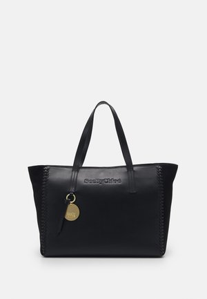 Czarna skórzana torba typu tote marki SeeByChloé z zaplecionymi detalami po bokach, podwójnymi uchwytami oraz okrągłym złotym zawieszką z logo przymocowaną do jednego z uchwytów.