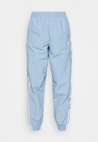 Ljusblå Adidas träningsbyxor med elastisk midja och mudd, med vit tre-stripes detaljer och Adidas-logotyp på benen.