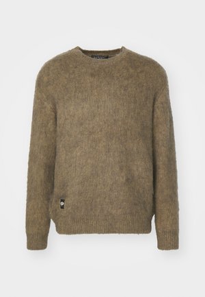 Brown knitted sweater with a crew neckline, long sleeves, and ribbed cuffs. Features a small brand label on the lower side.