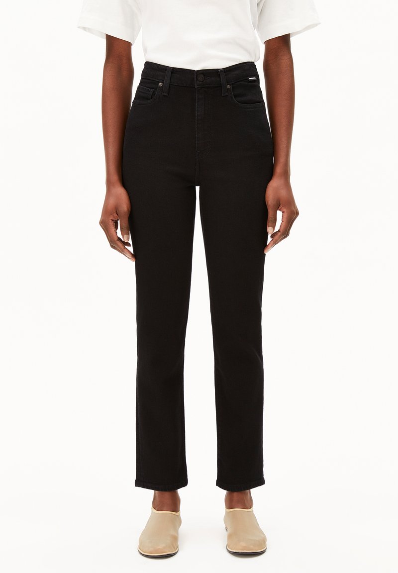 Jean noir taille haute, coupe slim, avec cinq poches et des coutures discrètes. Le matériau est en denim, présentant un design classique à jambes droites.