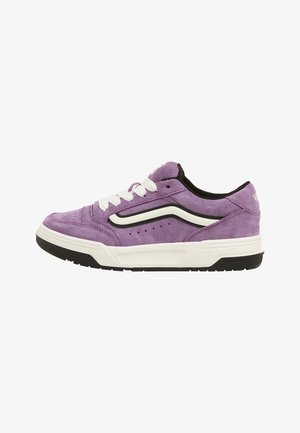 Fioletowe zamszowe sneakersy low-top z białymi sznurówkami, czarnymi akcentami i białą podeszwą środkową. Posiadają klasyczny pasek po boku oraz perforowane detale.