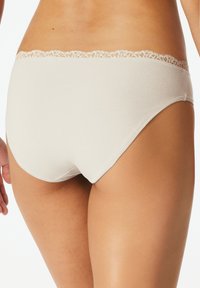 Beige Baumwollslip mit einem dekorativen Spitzenbund, der eine glatte Textur und einen klassischen Schnitt für Komfort bietet.
