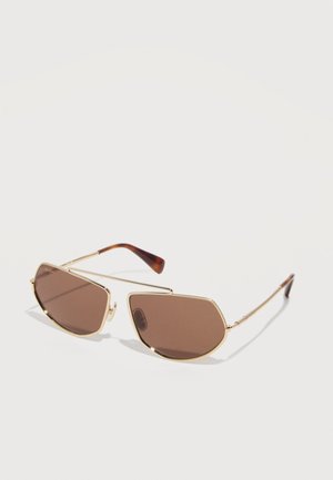 Paire de lunettes de soleil élégantes avec montures métalliques géométriques dorées et verres teintés marron reposant sur une surface blanche.