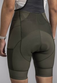 Olive green high-waisted cycling shorts with smooth, stretchy fabric. Features flat seams and a padded area for comfort.