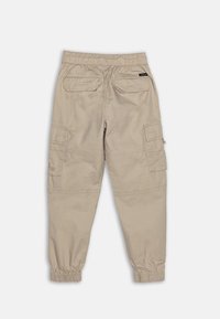 Beige cargo bukser med elastisk talje, oppbrettede anklene, og flere lommer. Glatt stoff med sømdetaljer og en avslappet passform.