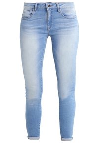 Světle modré džíny skinny s mírně opraným vzhledem, pěti kapsami a ohrnutými nohavicemi nad kotníkem.