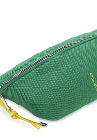 Zelený látkový sáček s texturovaným povrchem, stříbrným zipem a žlutým táhlem zipu. Vytlačené logo v žluté barvě na jedné straně.