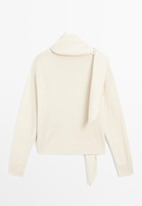 Maglione a maniche lunghe di colore crema con sciarpa integrata appoggiata sulla spalla, presentato piatto su uno sfondo bianco.