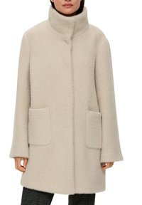 Beige wollen blend jas met een hoge kraag, gestructureerd patroon, twee voorkruiszakken en brede mouwen. Tot onder de heupen en een losse fit.