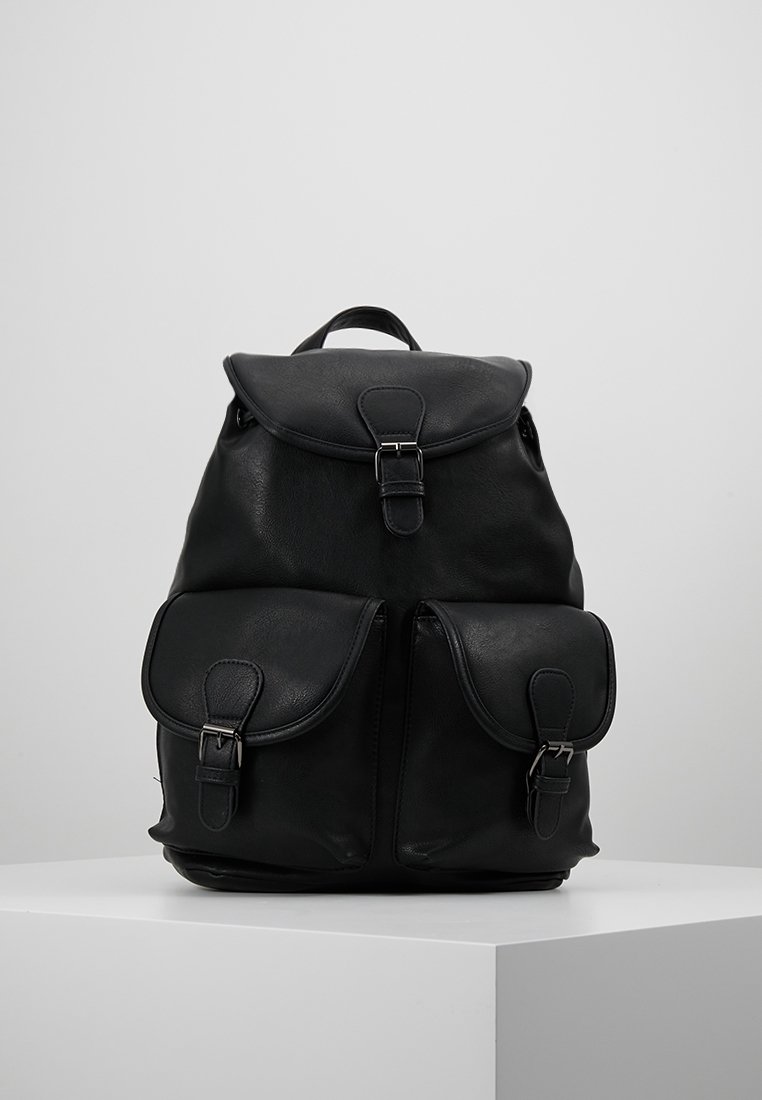 Czarny skórzany plecak z górną klapą i zapięciem, z dwiema przednimi kieszeniami z zapięciami, umieszczony na białym piedestale na jednolitym tle.