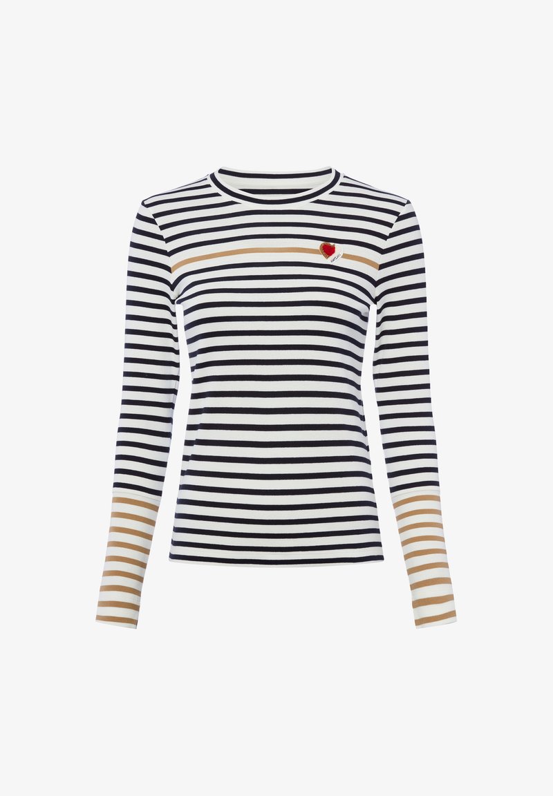 Chemise blanche à manches longues avec des rayures horizontales noires, une bande beige traversant la poitrine et les avant-bras, et un petit patch cœur rouge sur le côté supérieur gauche.