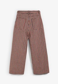 Pantaloni cu talie înaltă și picior larg, cu un model de carouri roșu, alb și negru, și două buzunare aplicate pe spate, pe un fundal alb.