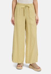 Lichtgele, wijde linnen broek met een elastische tailleband en een trekkoord. Heeft zijsplitten voor extra bewegingsvrijheid en comfort.