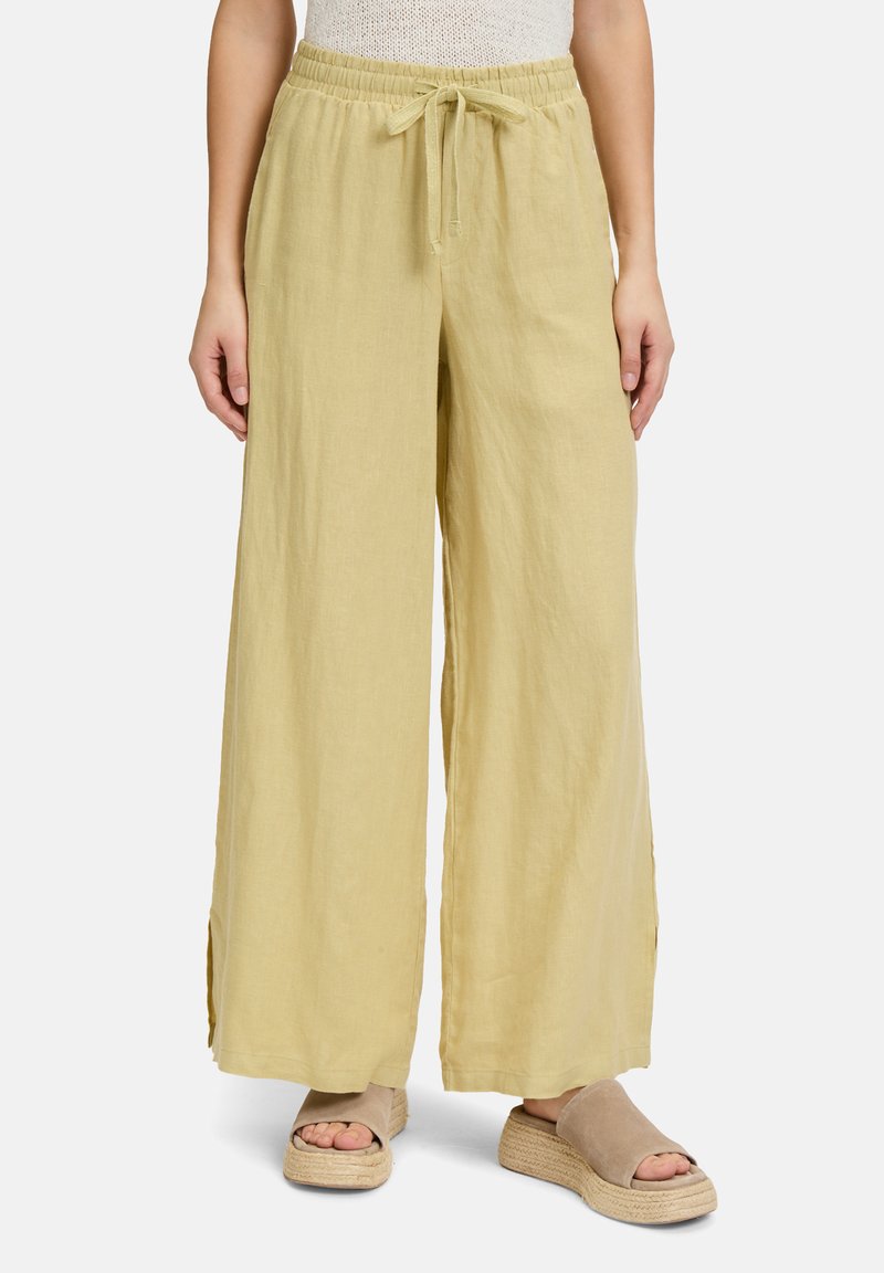 Lichtgele, wijde linnen broek met een elastische tailleband en een trekkoord. Heeft zijsplitten voor extra bewegingsvrijheid en comfort.