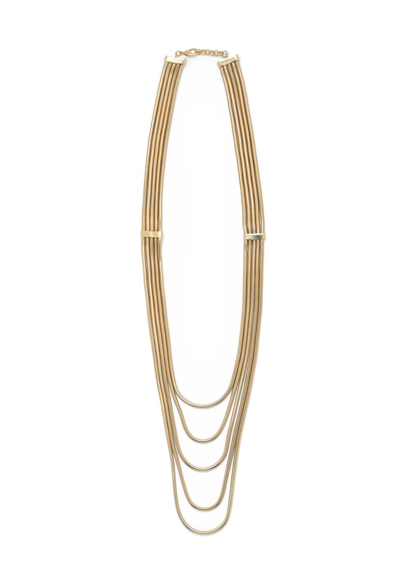 Auksinės spalvos daugiagyslė kaklo grandinėlė su keturiomis ilgio kaskadomis, pagamintomis iš lanksčių gyvačių grandinėlių. Užsegimas gale leidžia reguliuoti ilgį.