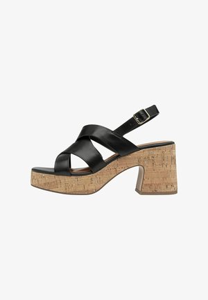 Zwarte leren platform sandalen met kruisstropen, kurken blokhak en verstelbare enkelband. Voorzien van een textuur oppervlak van kurk.