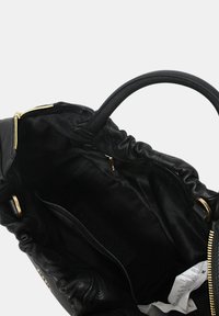 Borsa a mano in pelle nera con apertura arricciata e hardware dorato. L'interno presenta una fodera in tessuto liscio e un'etichetta cucita.