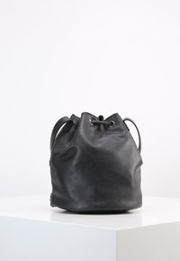 Borsa a secchiello nera in pelle con chiusura a coulisse, texture liscia e una sola tracolla, con base rotonda e silhouette morbida.