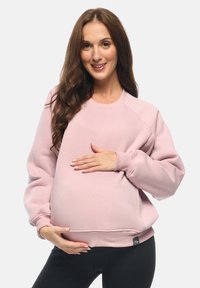 Felpa da maternità rosa con scollatura rotonda, polsini e orlo a costine. Tessuto morbido, vestibilità rilassata, ideale per il comfort durante la gravidanza.