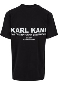 Black cotton t-shirt featuring large white print on the back: "KARL KANI" and "THE ORIGINATOR OF STREETWEAR," with established year and trademark details.