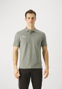 Šedé polo tričko s krátkými rukávy, vyrobené z texturované tkaniny. Na levé straně hrudi se nachází bílé logo a má klasický design límce.